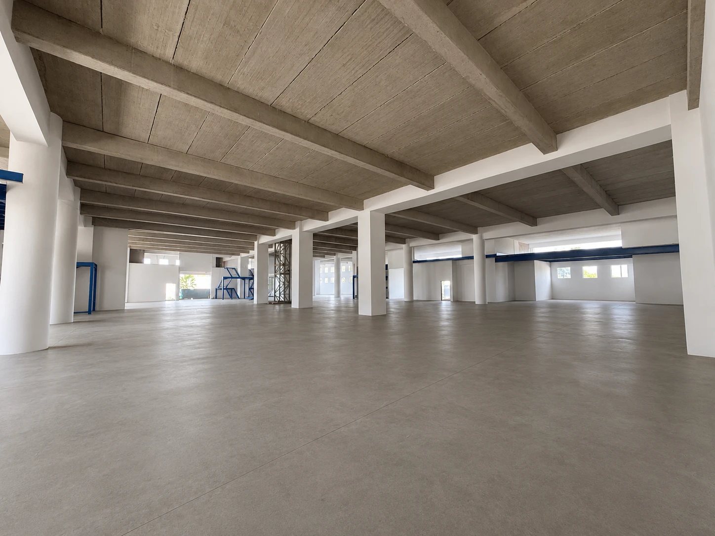 Photo de chantier du rez-de-chaussée sous un autre angle, poutres béton et mezzanine bleue